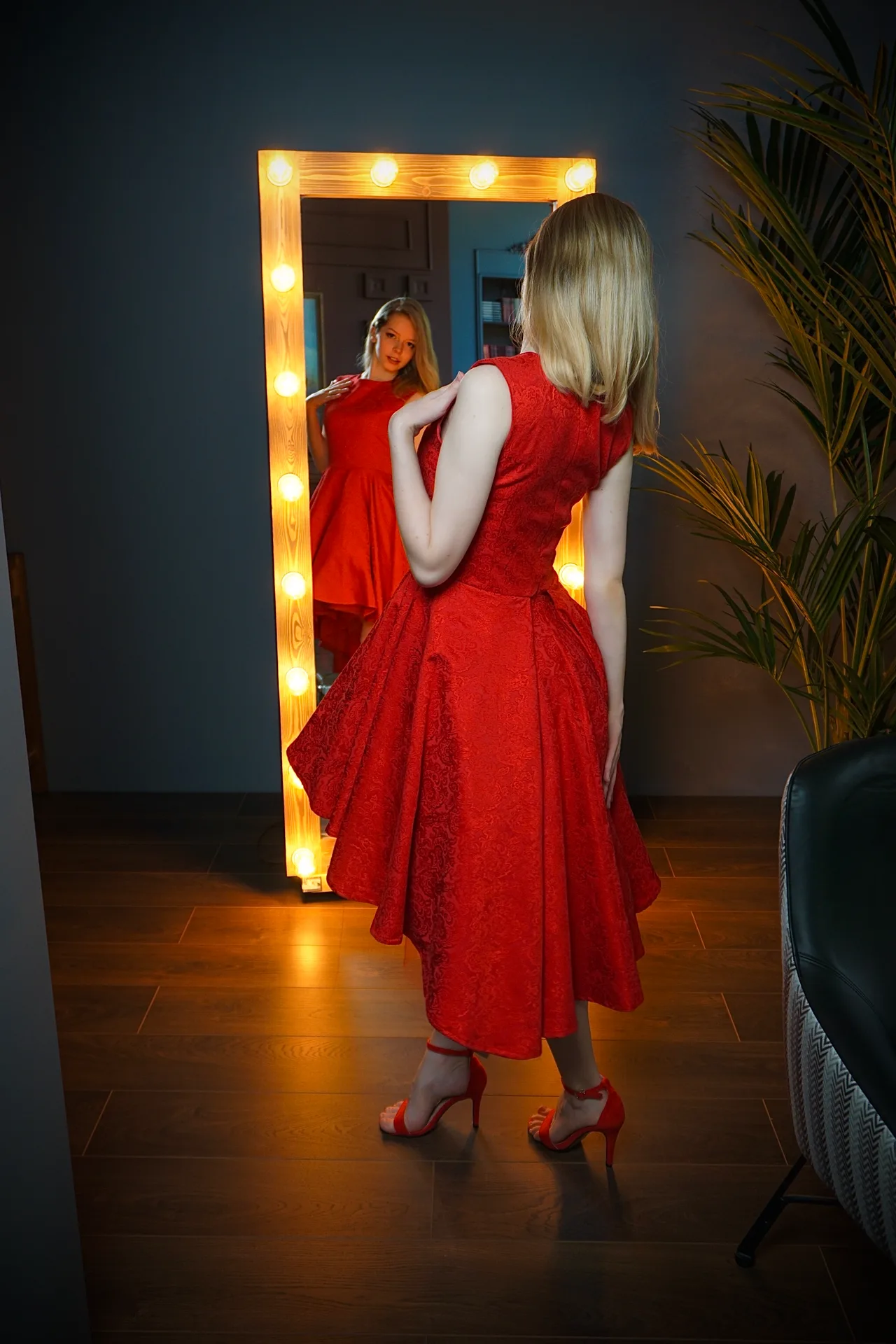 Red dress at a lit mirror